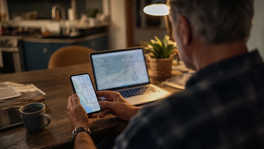 Man at a kitchen table checking a map on his phone